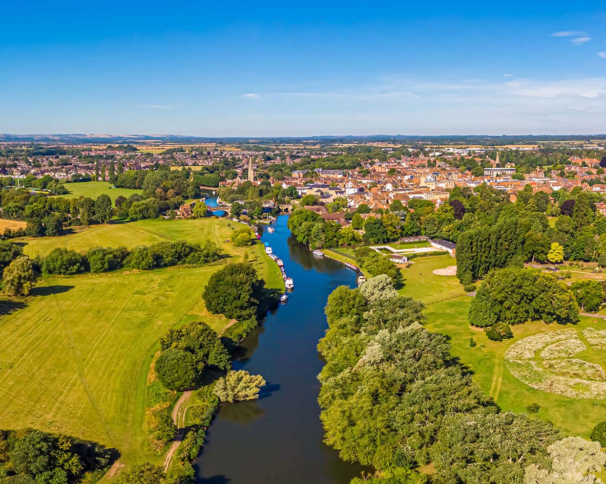 Aerial photo of a river through British countryside and a town in the distance